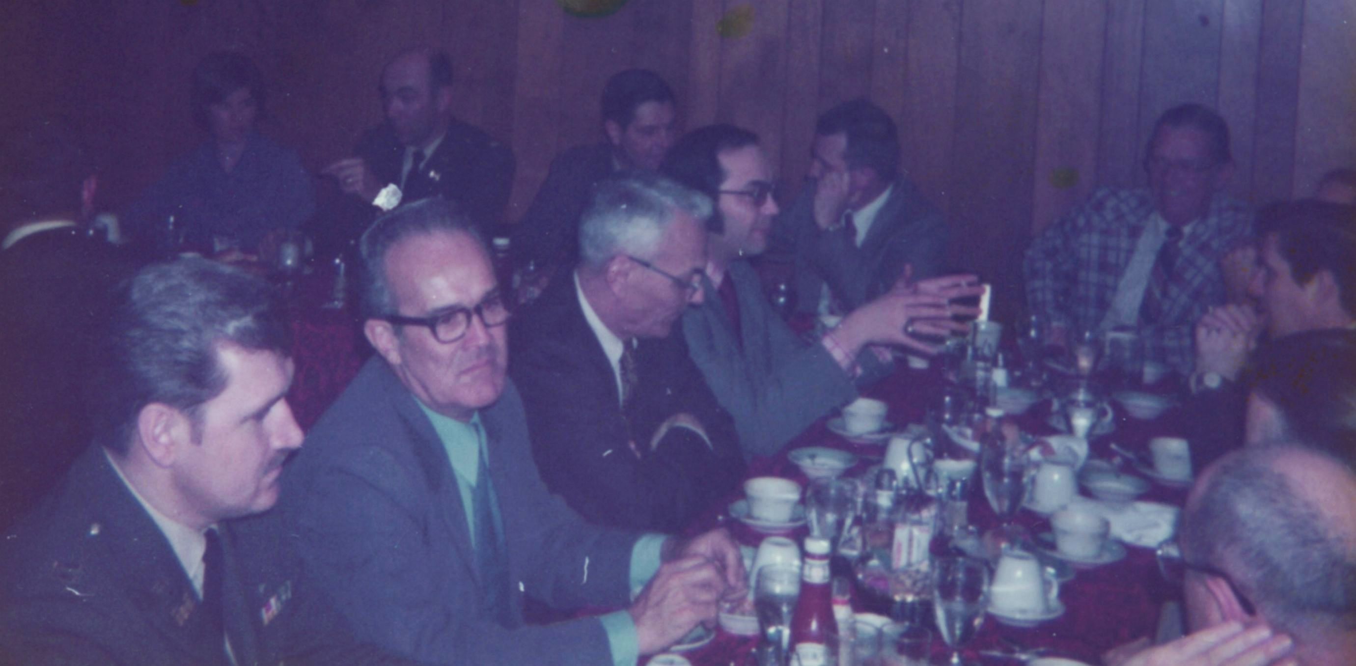 42-At Table, Faces Showing: Major Czejauskus, Jim Baker, Bob Parsons, Paul Nadziejko, Elmer Huizinga, Pete Puricelli